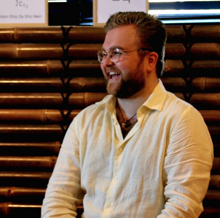 Marijn Jansen met een grote lach in een linnen overhemd