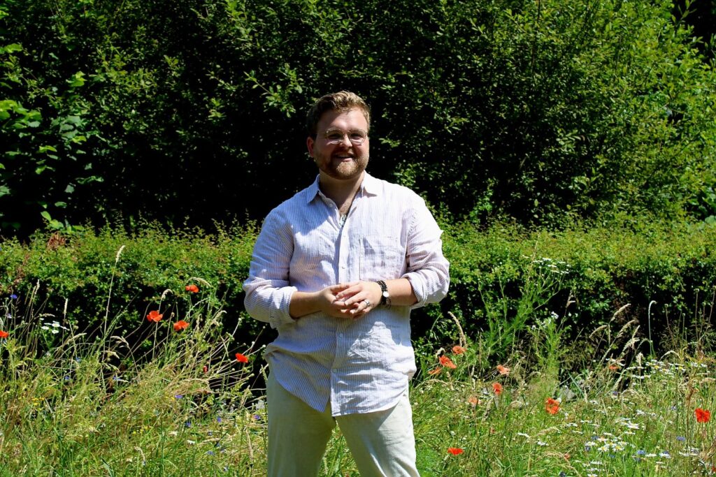 Marijn Jansen lachend in een veld met klaprozen