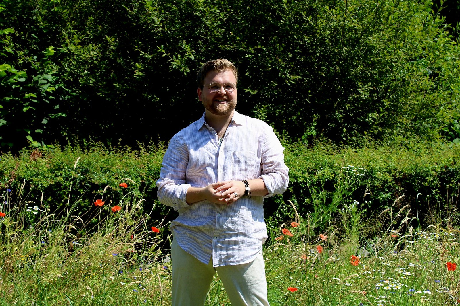 Marijn Jansen lachend in een veld met klaprozen